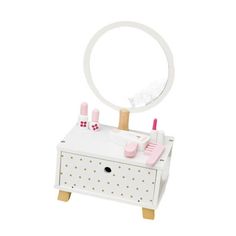 a white vanity with pink accessories and a mirror