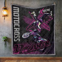 a wall hanging on the side of a building with a motorcycle rider in purple and black