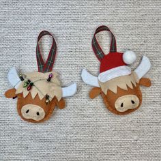 two christmas ornaments made to look like cows with horns and bells on their heads are sitting on the carpet