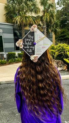 a woman wearing a graduation cap with flowers on it's head and writing on the side