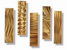 gold metal wall art pieces on a white background