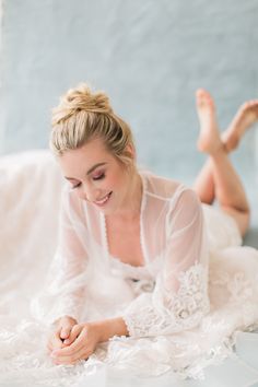 a woman laying on top of a white bed