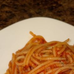 a white plate topped with spaghetti and sauce