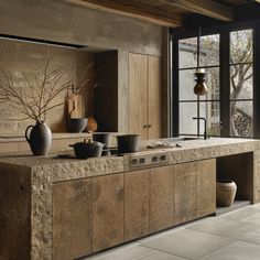 a kitchen counter with pots and pans on it, next to an open window