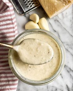 a spoon in a jar with peanut butter on it next to bread and other ingredients