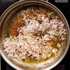 onions are being cooked in a frying pan on the stove top with seasonings