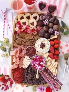 a tray filled with chocolate covered strawberries and other desserts on top of a table