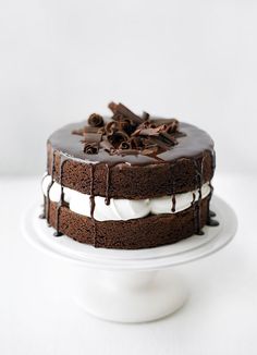 a cake with chocolate icing and white frosting on a plate in front of a white background