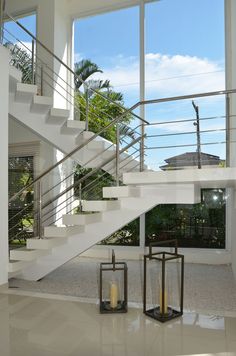 two candles sitting on top of a table next to a set of white staircases