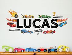 there is a wall decal that says lucas with racing cars and flames on it