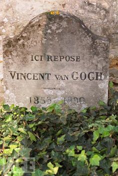 a headstone is surrounded by ivy in front of a stone wall with the words vicent van gogh on it