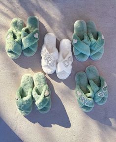 four pairs of slippers are laying on the sand