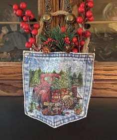 a christmas decoration hanging from the side of a wooden pole with red berries and pine cones