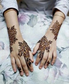 two hands with henna tattoos on them