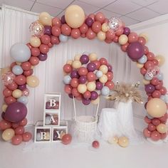 an arch made out of balloons and other items for a baby's first birthday