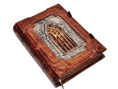 a book with an intricate design on the front and inside cover is opened to reveal a wooden door