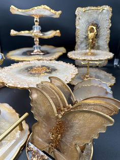 several pieces of gold and white glass with decorative designs on them, including two candlesticks