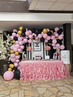 a table topped with pink, black and gold balloons