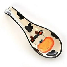 a glass spoon with a cow design on it's side and black dots around the neck