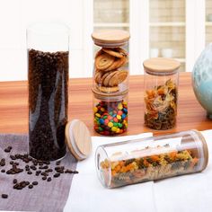 several jars filled with different types of cookies and candy on top of a wooden table