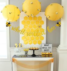 a table topped with yellow honeycombs next to a sign and some paper lanterns