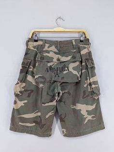 "REMINDER: THIS IS USED CLOTHING PLEASE DO NOT EXPECTED IT LIKE TO BE NEW OR IN PRISTINE CONDITION Feel free to contact me for any question. I'll assist you with my pleasure. W30 Vintage Avirex Cargo Short Pants Avirex Usa Camo Woodland Pattern Military Utility Shorts Avirex Camo Green Cargo Pocket Short Size 30 *All measurements are taken with the garment laying flat & doubled. Measurement in inches. We recommend giving yourself an extra few inches for ease of fit Size On Tag: M but fits more like: W30 Waist :- 30\" Rise :- 12.5\" Thighs :- 25\" Hips :- 45\" Inseam :- 12.5\" Length :- 22\" CONDITIONS: Excellent Vintage Conditions. Please pay close attention to measurements provided. Do not rely on tag size as pre-worn items may have been altered, stretched or shrunk & vintage sizes do not Camouflage Short Length Bottoms With Side Pockets, Camouflage Short Bottoms With Pockets, Military Style Short Bottoms For Streetwear, Vintage Short Bottoms With Cargo Pockets, Military Style Short Bottoms With Pockets, Military Style Shorts With Pockets, Military Style Camouflage Shorts With Side Pockets, Military Style Camouflage Cargo Shorts, Military Camouflage Shorts With Multiple Pockets