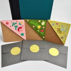 four pieces of crafting paper with different designs on them, one is folded and the other has gold coins