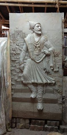 a large white statue sitting on top of a stone slab