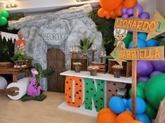 a birthday party with balloons and decorations in the shape of animals, trees, and letters