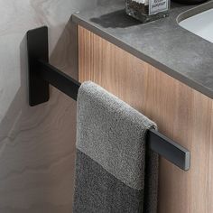 a bathroom sink with a towel hanging on the wall next to it's faucet