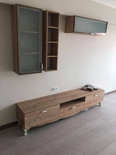 an empty room with a large wooden entertainment center and two glass doors on the wall