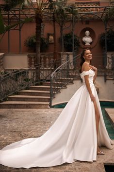 a woman in a white wedding dress posing for the camera