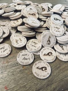 a pile of white buttons sitting on top of a wooden table next to each other