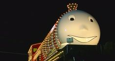 a large white object with lights on it's sides and eyes, in the shape of a smiling face