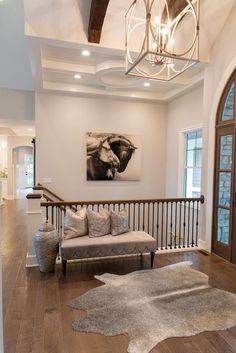 a living room filled with furniture and a chandelier hanging from the ceiling over a wooden floor