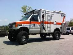 an orange and white truck parked in a parking lot