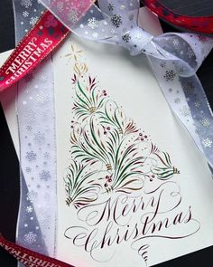 a christmas card with a tree on it and ribbon tied around the bottom of it