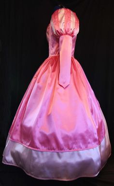 a pink and purple dress on display in front of a black background with white trim