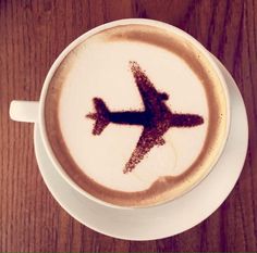 a cup of coffee with an airplane drawn on it