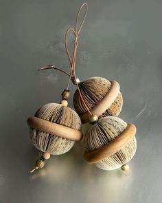 three seashells are sitting on top of each other, one has a string attached to it