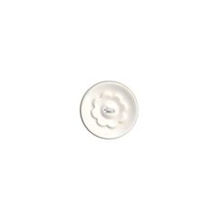 a white button with a flower in the center on a white background that appears to be part of a sewing machine