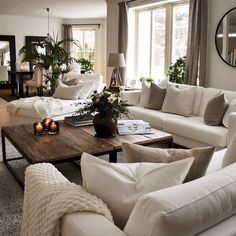 a living room filled with white furniture and lots of pillows on top of it's couches