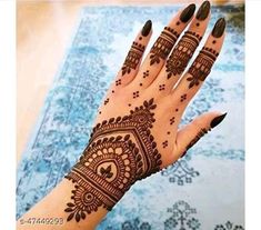 a woman's hand with henna tattoos on it