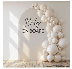 a baby on board balloon arch with white balloons