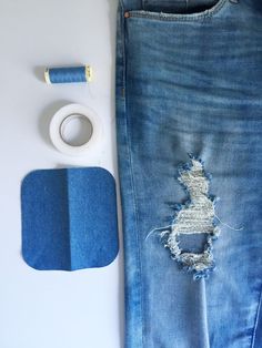 a pair of ripped jeans next to a roll of tape