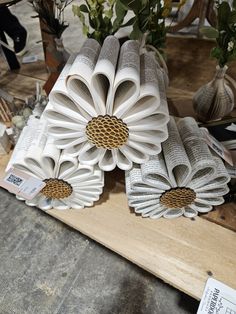 several pieces of art made out of rolled up newspaper with flowers in the middle and leaves on top