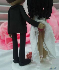 a bride and groom figurine are standing next to each other