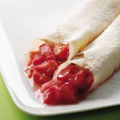 two bananas and strawberries on a white plate