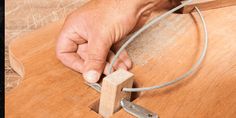 a person is working on a piece of wood with a string attached to the end