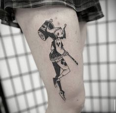 a person with a tattoo on their leg holding a baseball bat and wearing a hat